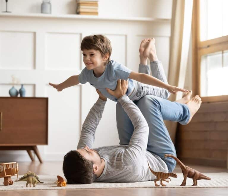 Children games: dad plays with kid, making airplane